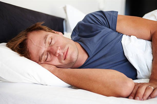 Young man sleeping peacefully while in bed at home