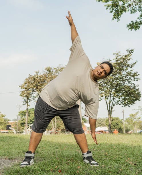 middle-aged man stretching his body in the park outdoors