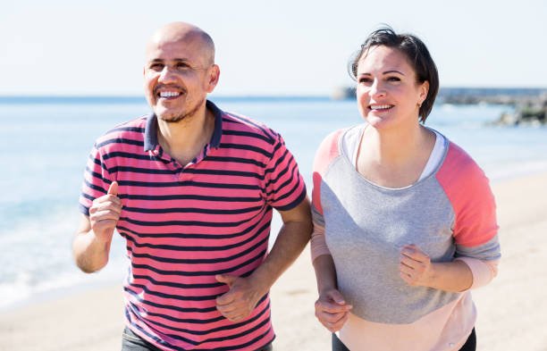 outdoors portrait of a smiling running mature couple 50s