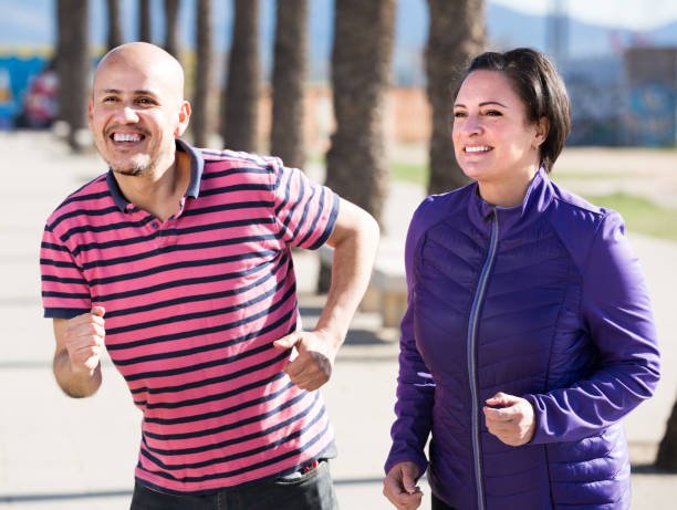 outdoors portrait of a smiling running mature woman and man