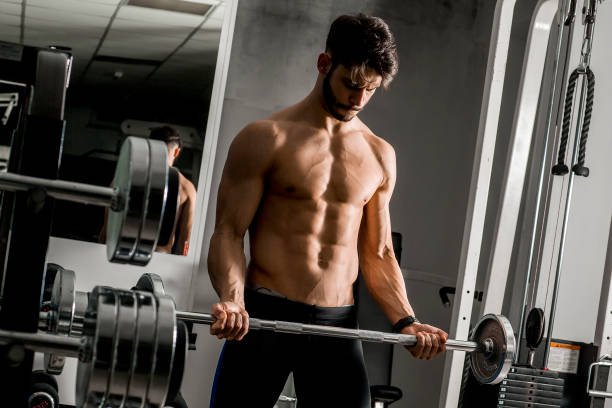 Portrait of strong and handsome young man doing exercise with dumbbells