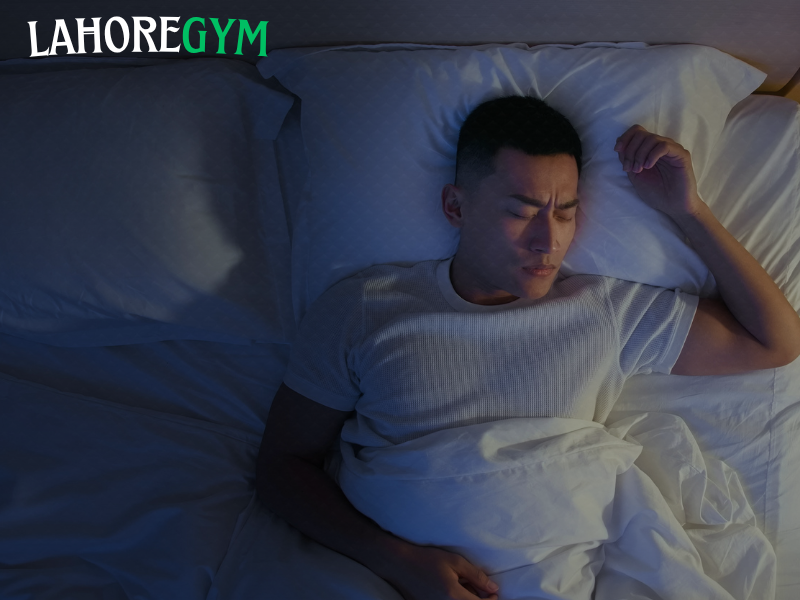 A tired man sitting on a gym bench, looking exhausted after a workout, symbolizing how poor sleep affects muscle recovery and weight loss.